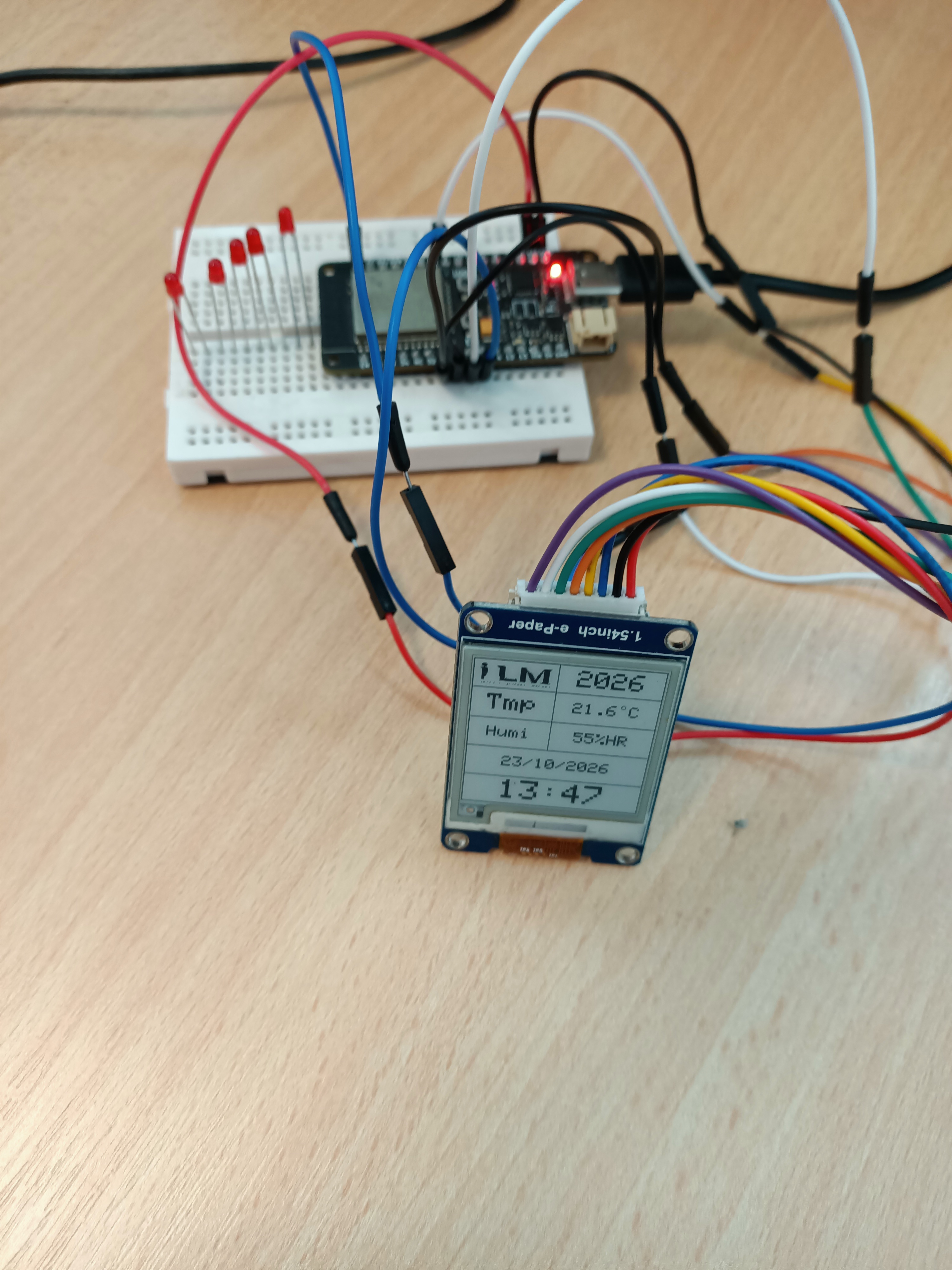 Actual ESP32 build with a logo, simulated temperature and humidity, date and time on an e-paper screen
